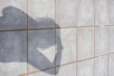 Bir kiremit üzerinde bir kişinin gölgesi