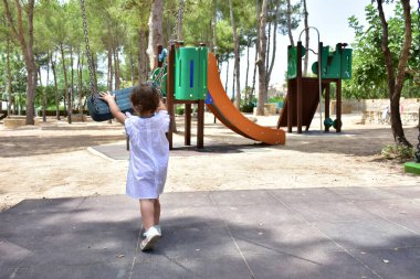 Manzaranın arka planında küçük bir çocuk yürüyor.,