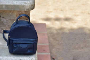 Bir ağacın yanında siyah bir sırt çantası.,