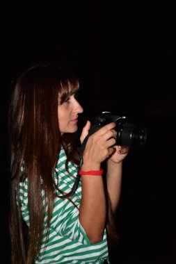 Siyah arka planda kamerası olan bir kız.