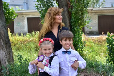 Kafasında çelenk olan güzel bir kız ve bir oğlan ve anne.,