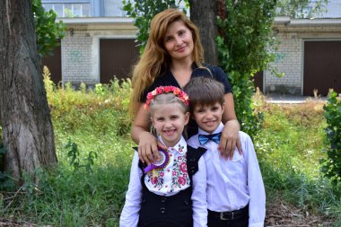 Kafasında çelenk olan güzel bir kız ve bir oğlan ve anne.,