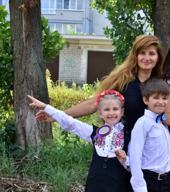 Kafasında çelenk olan güzel bir kız ve bir oğlan ve anne.,