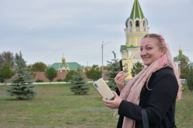 Çevrede telefonu olan sarışın bir kız.