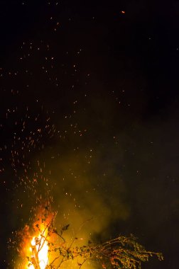 Şenlik ateşi gece alevler ile kıvılcım bir siyah arka plan üzerine