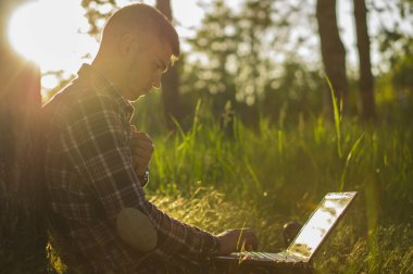 Dizüstü bilgisayar açık ile gülümseyen genç adam