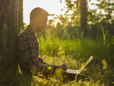 Dizüstü bilgisayar açık ile gülümseyen genç adam
