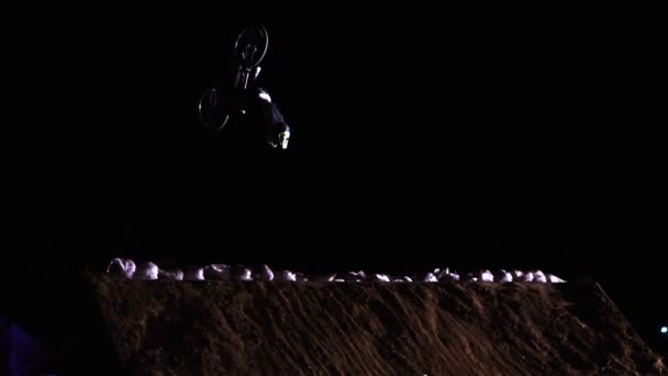 Movimiento lento del hombre extremo Los atletas están haciendo una voltereta hacia atrás en la bicicleta MTB Bmx mientras Dirtjumping en la noche en el Festival Extreme Ucrania 2017 — Vídeos de Stock