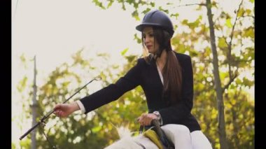 Genç esmer jokey kız parkta at okşama