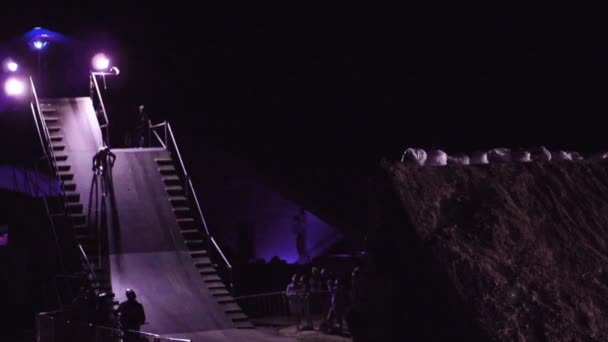 Zeitlupe Video von Extremsportler Mann macht einen erstaunlichen Trick auf dem mtb bmx Fahrrad während Dirtjumping in der Nacht auf dem Festival extreme ukraine 2017 — Stockvideo