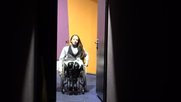 Flickan på en rullstol som kommer på bio. Funktionshindrade fritid — Stockvideo
