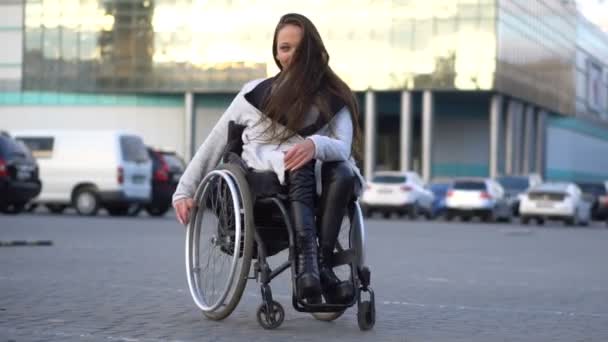 Atrakcyjna dziewczyna niepełnosprawnych tańczy na wózku inwalidzkim na parking. Jesienny wypoczynek — Wideo stockowe