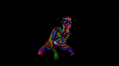 Güzel genç seksi kız iç çamaşırı vücudunda ultraviyole boya ile dans. Renk ışık neon bodyart kızla.