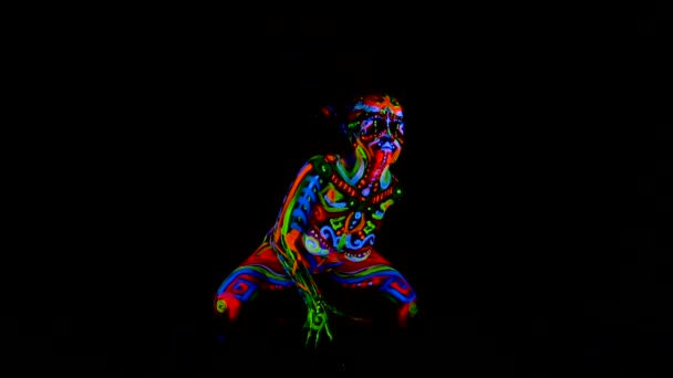 Mooie jonge sexy meisje in lingerie dansen met ultraviolette verf op haar lichaam. Meisje met neon bodyart in kleur licht. — Stockvideo