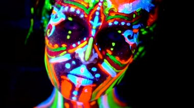 Yakın çekim duygular bir genç bodyarted avatar kız ultraviyole ışık. Kadın renk ışık yüzü.