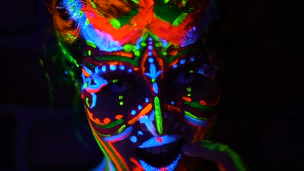 Close-up emoties van jonge bodyarted avatar girl in ultraviolet licht. Gezicht van de vrouw in de kleur licht. — Stockvideo