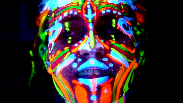 Close-up emoties van jonge bodyarted avatar girl in ultraviolet licht. Gezicht van de vrouw in de kleur licht. — Stockvideo