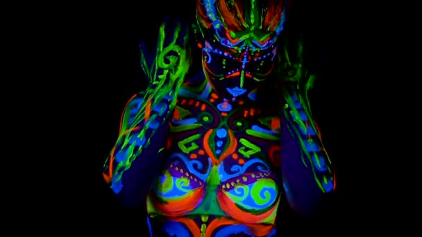 Mooie jonge sexy meisje in lingerie dansen met ultraviolette verf op haar lichaam. Meisje met neon bodyart in kleur licht. — Stockvideo