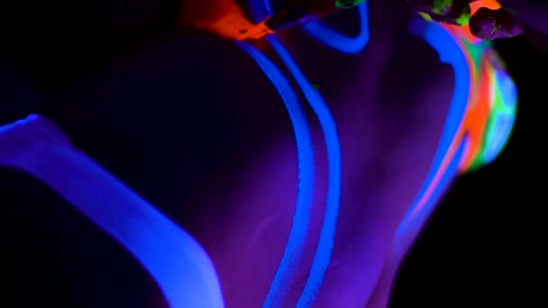 De bodyart ultraviolet schilder trekt op de huid van mooie jonge sexy meisje. — Stockvideo