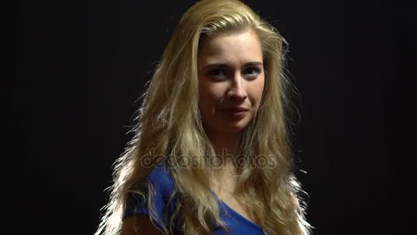Сексуальная блондинка в синем платье приглашает в студию с черным фоном . — стоковое видео