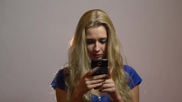 Menina Loira Sexy bonita em vestido azul conversando com telefone no estúdio — Vídeo de Stock