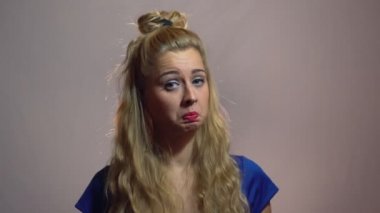 Mavi elbiseli güzel seksi sarışın kızı gösterilen başparmak telafi Studio ile arka plan ışıktır.