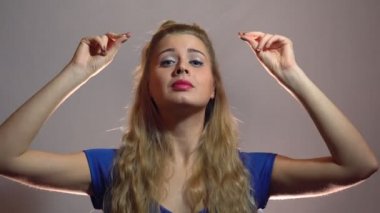 Mavi elbiseli güzel seksi sarışın kızı gösterilen başparmak Youre Best Studio anlamı ışık arka plan ile size kalmış. Motivasyon video
