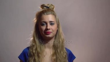 Mavi elbiseli güzel seksi sarışın kızı gösterilen başparmak Youre Best Studio anlamı ışık arka plan ile size kalmış. Motivasyon video