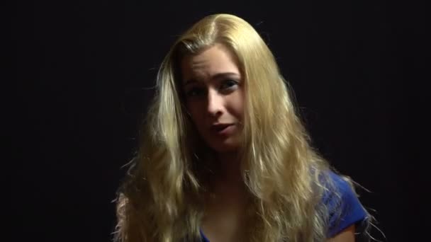 Schöne sexy blonde Mädchen in blauem Kleid singt und tanzt im Studio mit schwarzem Hintergrund. — Stockvideo