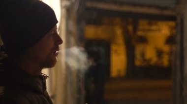 Ev ağ geçidi'nde, soğuk hava gece şehir tütün sigara haddeleme el genç adam