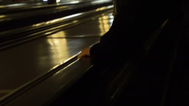 4K Anonymous mans hand holding an escalator going up as blurred passengers descend on the other side in slow motion, shot on RED EPIC — Stock Video