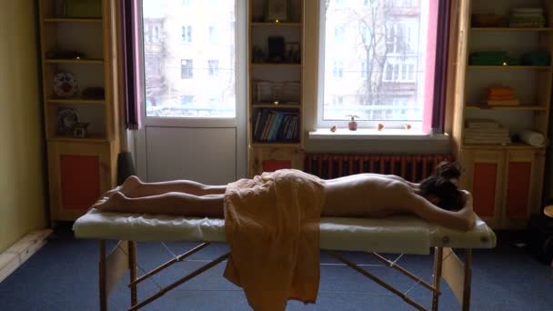 Vista da sala. The Girl is Lay on Massage Table e espera pela sessão de massagem. Massagem Ayurvédica Abyanga . — Vídeo de Stock