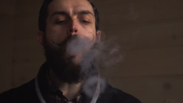 Uomo hipster con barba e seni vaporizzare una sigaretta elettronica. Vaper Hipster vaporizzatore di fumo ed esala anelli di fumo . — Video Stock