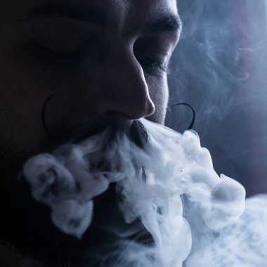 Sakal ve Mustages Vaping elektronik sigara olan adam. Vaper Hipster Buharlaştırıcı ve burun akışından Exhals duman duman.