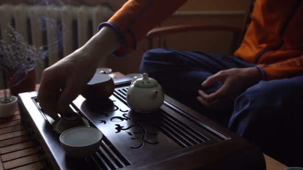 Ο άνθρωπος είναι ρίχνει τσάι γιασεμί σε τσαγιέρα στην παραδοσιακή κινεζική τελετή του τσαγιού. Σύνολο εξοπλισμού για πίνοντας τσάι — Αρχείο Βίντεο