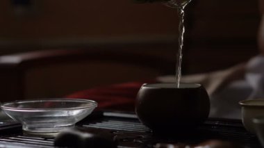 Geleneksel Çince çay töreninde demlik çay dökme. Donatım için çay içme ayarla