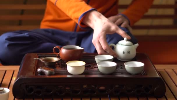 Man Verter té Puer en la tetera en la ceremonia tradicional del té chino. Conjunto de equipos para beber té — Vídeo de stock