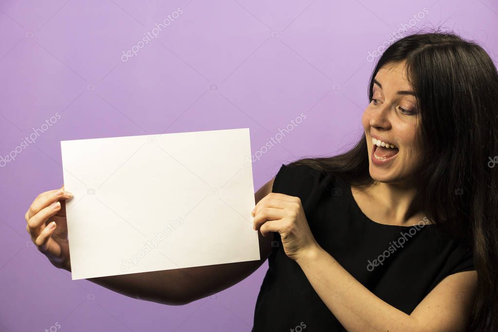 Surprised Young Brunette Girl holding empty blank white board. Leaflet presentation. Pamphlet hold hands. Girl show clear offset paper. Sheet template. Booklet design sheet display read first person.