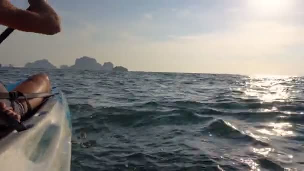 Starker Mann auf dem Kajak im offenen Meer. Sonnenuntergang über den Felswänden. railey beach, krabi, thailand. — Stockvideo