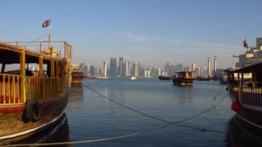 Doha Modern şehir manzarası gün atış, Katar, Orta Doğu. Doha gökdelenleri ile geleneksel ahşap Katar tekneler Corniche Broadway üzerinde görünümü