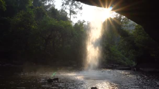 Blick vom Café unter dem malerischen Wasserfall im Dschungel zur Abendzeit. Wasser fällt durch Sonnenstrahlen in Pool im thailändischen Khao yai Nationalpark. — Stockvideo