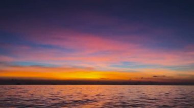 Güzel doğa ve deniz üzerine pembe ve turuncu Bulutların arasından kırma günbatımı