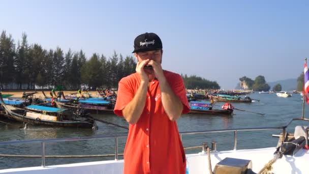 Freaky caucásico hombre tocando su arpa en el buque puerto antes de la salida a islas Farest de Krabi, Tailandia. — Vídeos de Stock