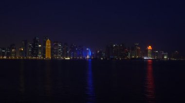 Doha gece şehir Basra Körfezi, gerçek zamanlı Video, Katar, Orta Doğu deniz suya yansıtan. Işıklandırılmış gökdelenler bir Batı Körfezi Körfez suya yansıyan. Mia park göster