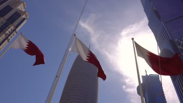 Doha, qatar - 12. Februar 2018: In der modernen Stadt wehen drei Nationalflaggen. Wolkenkratzer umgeben — Stockvideo