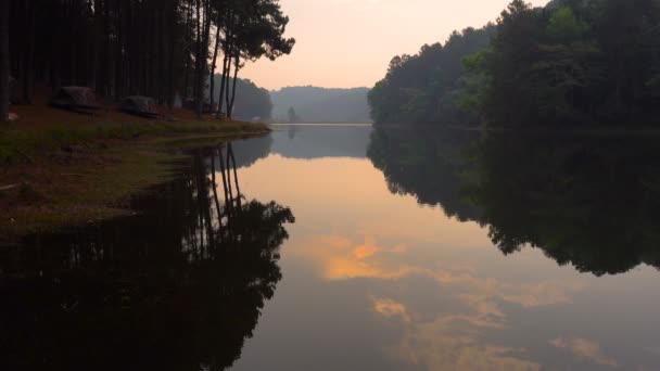 日出时山针叶林和云映在泰国南部的高原湖泊平静的水中, 湄洪儿地区. — 图库视频影像