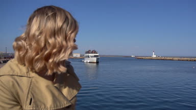 Hendek Vintage çanta çekici genç sarışın kadının mesafe Jacht iskelede oturuyor