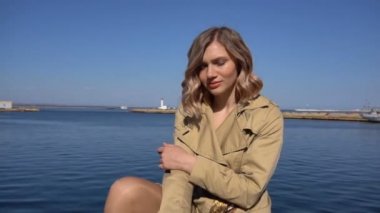 Çekici genç sarışın kadın Vintage çanta siperde Jacht iskelede oturuyor