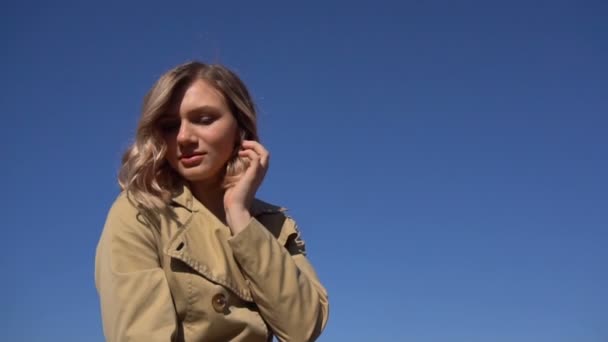 Retrato de una atractiva joven rubia en trinchera con una maleta vintage en el muelle de Jacht — Vídeo de stock