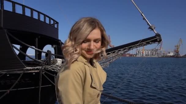 Aantrekkelijke jonge Blonde vrouw in Trench met Vintage koffer op de Jacht Pier glimlachen — Stockvideo